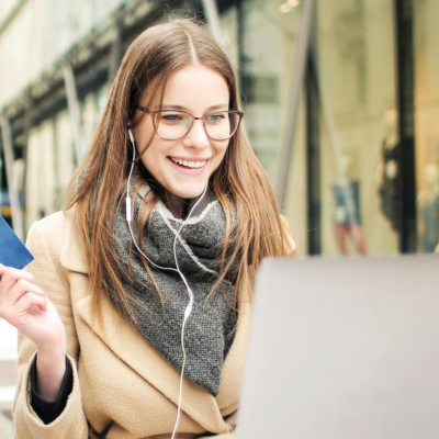 Woman using laptop while holding credit card